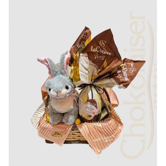 Cesta com coelhinho de pelúcia cinza, ovo de páscoa da cacau show, caixa de chocolate