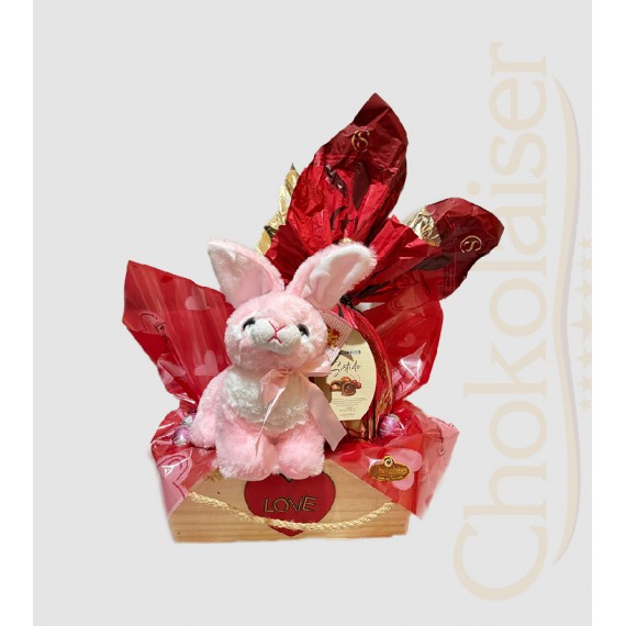 Cesta com coelhinho de pelúcia rosa, ovo de páscoa da cacau show, caixa de chocolate