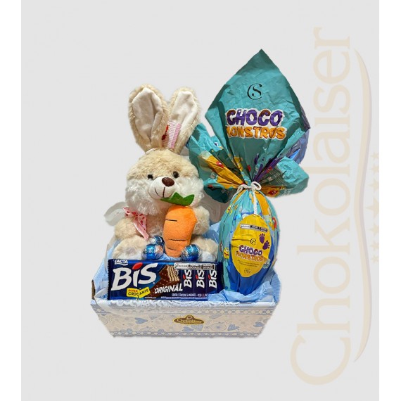 Cesta com coelhinho de pelúcia azul, chocolate da cacau show, ovo de páscoa